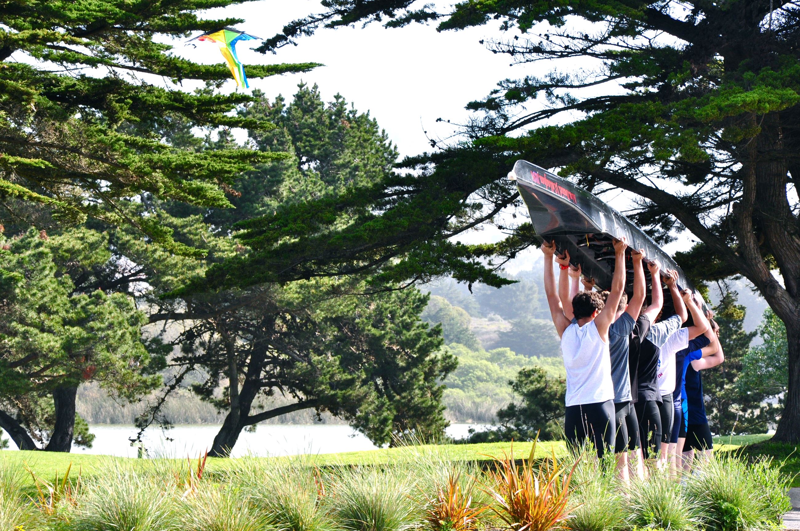 People carrying a canoe over their heads
