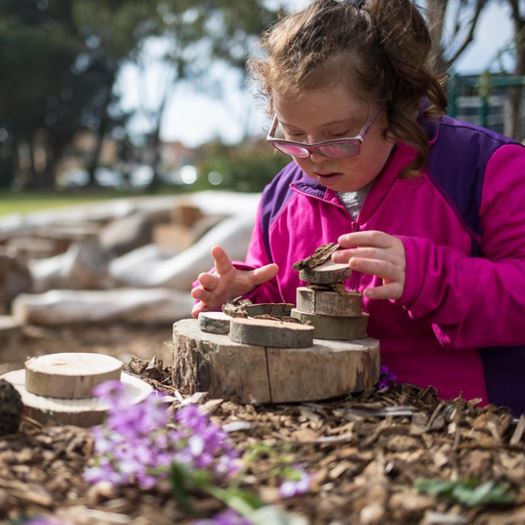 Girl building with rings of wood