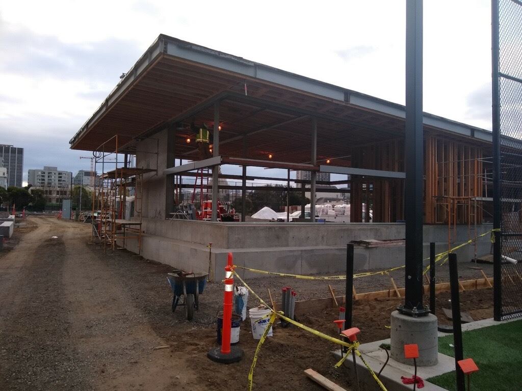 The image shows the exterior of the clubhouse building along with an internal view showing sprinkler