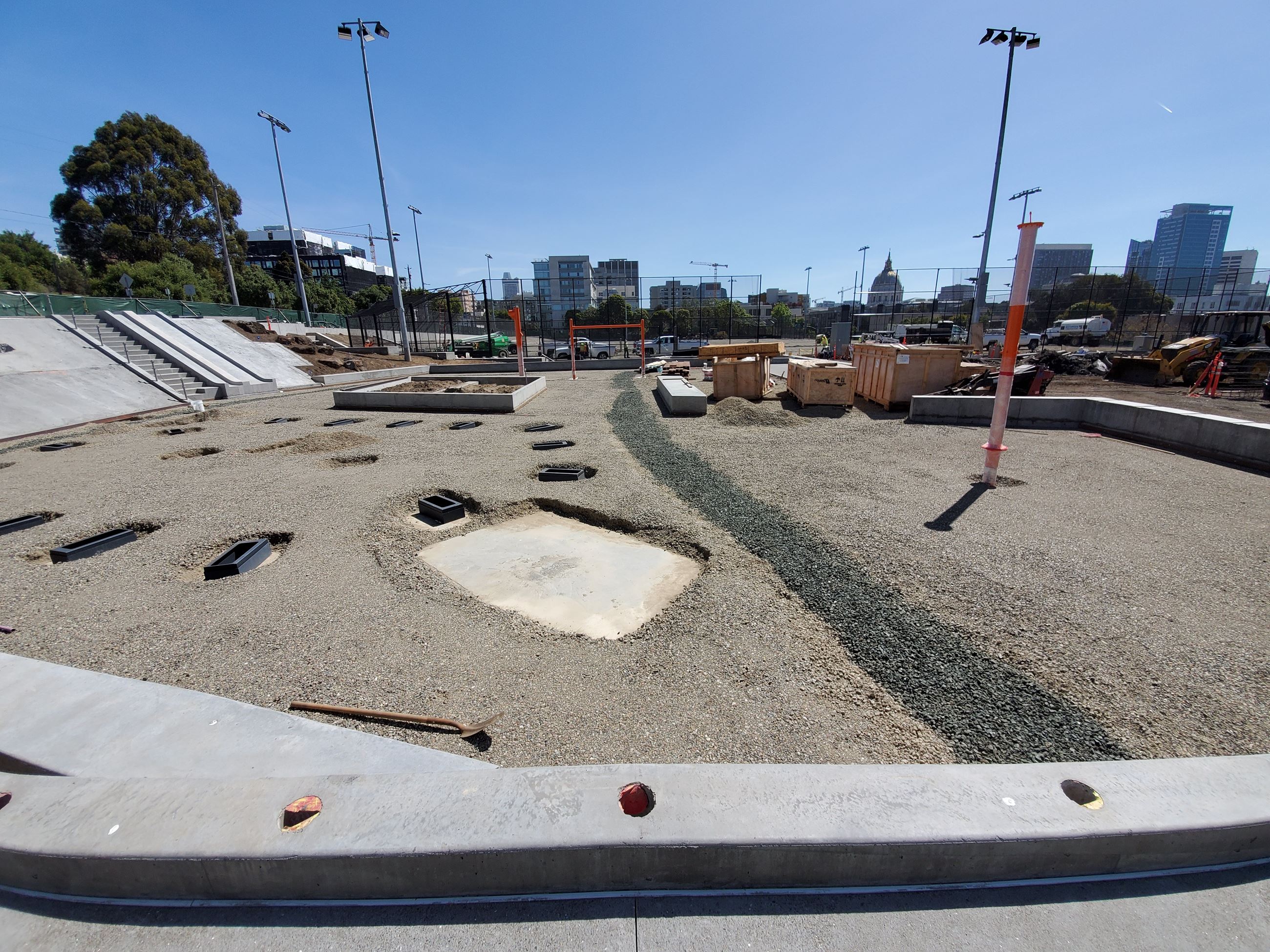 Photo is showing the footings for the playground structure surrounded by crushed gravel, constructio