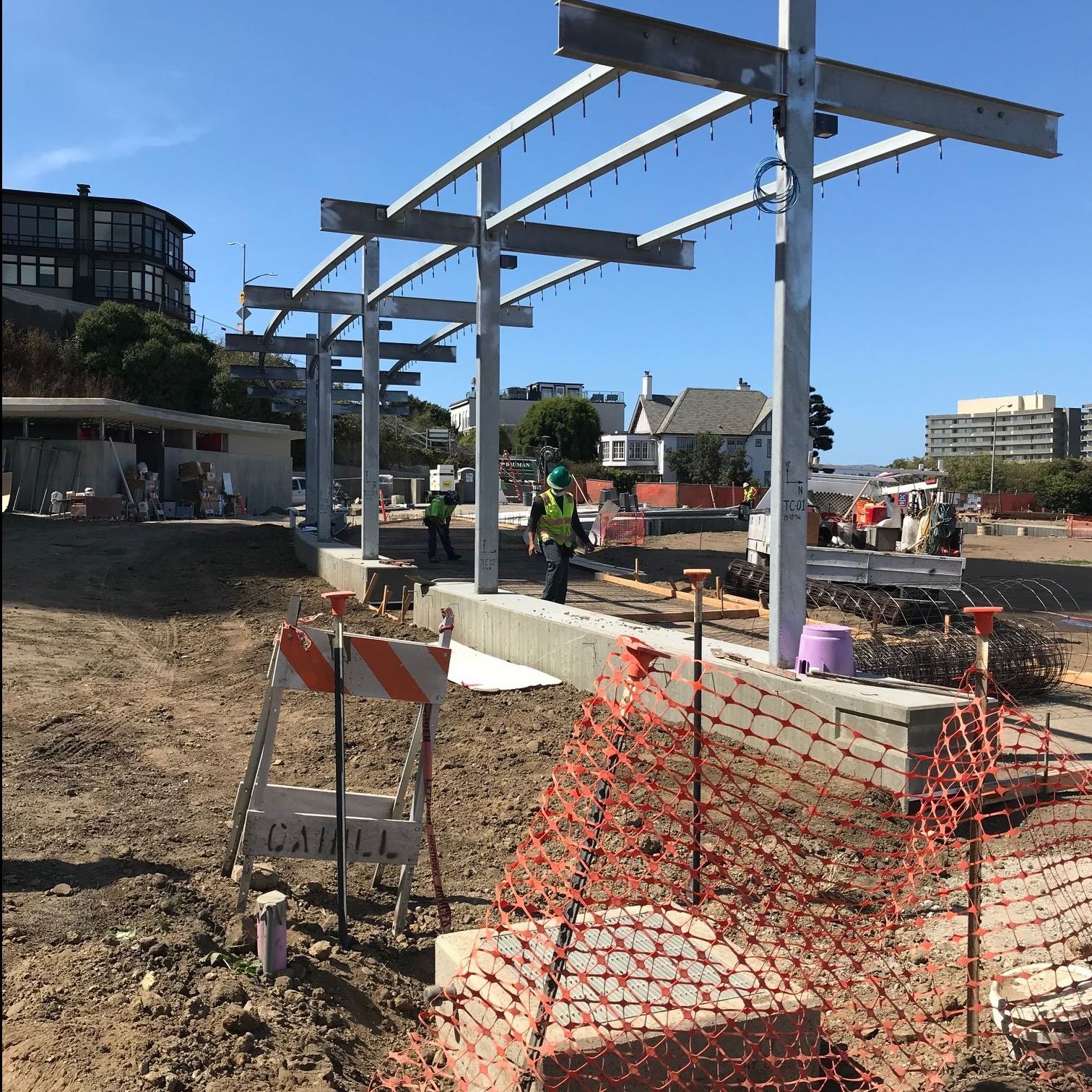 The trellis structure is under construction with metal poles and cement base.
