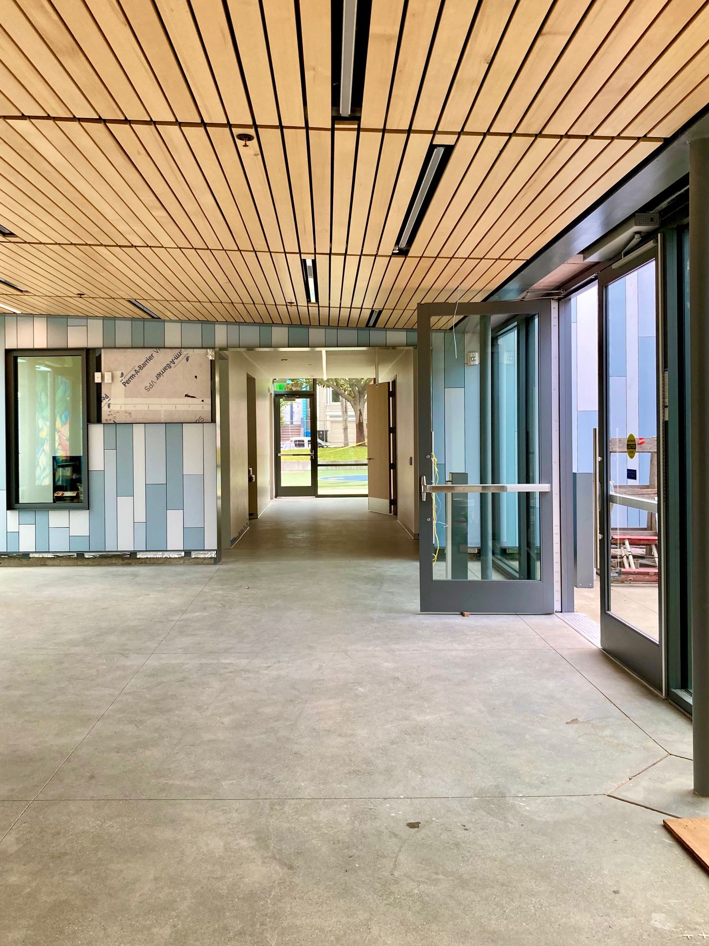 Clubhouse interior, blue and white tile walls, cement floor and wood slat ceiling
