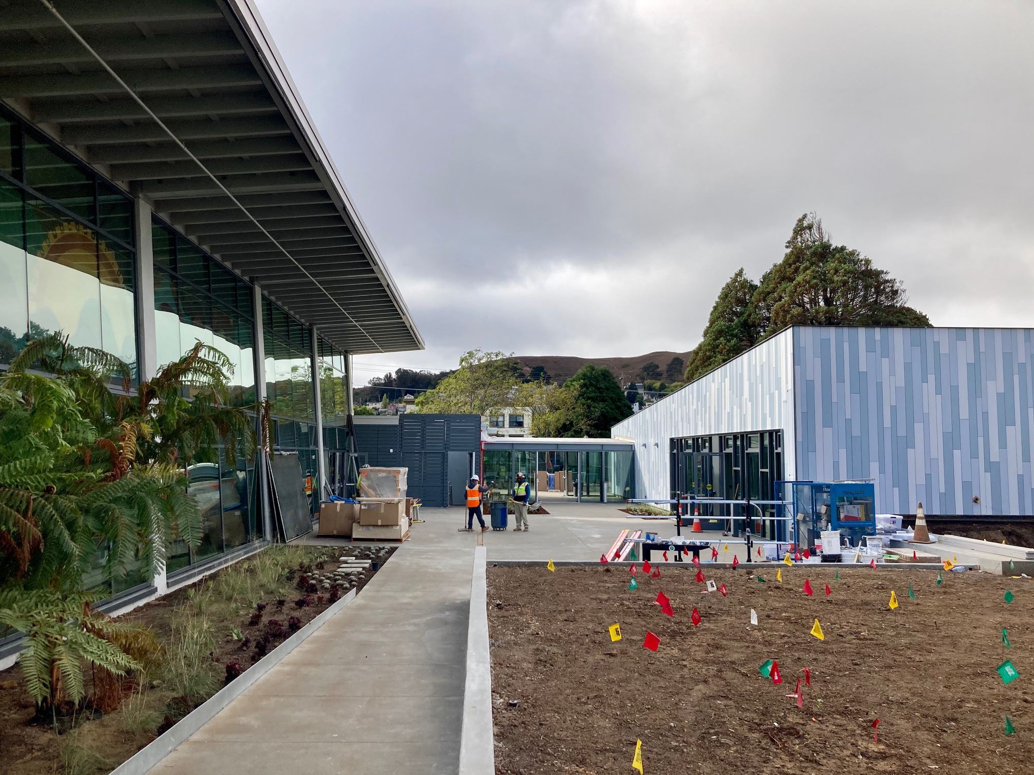 Blue and white tile clubhouse building, Pool Building, planter beds, cement pathway and patio