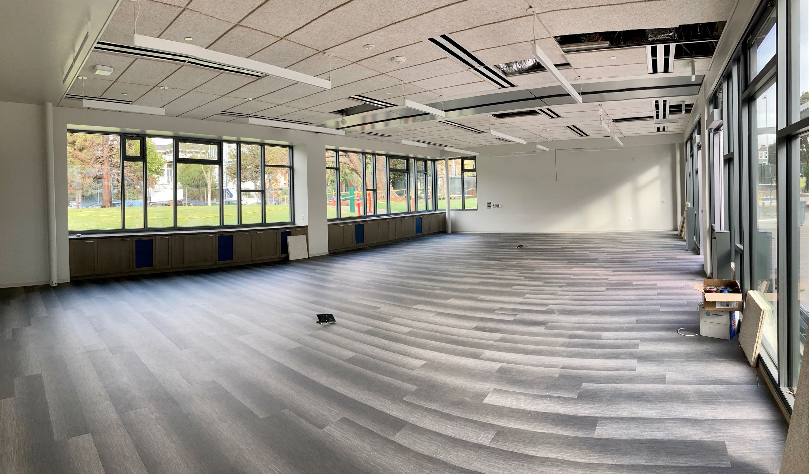 Interior of the clubhouse, grey and white variegated vinyl flooring, white ceiling, wall of windows