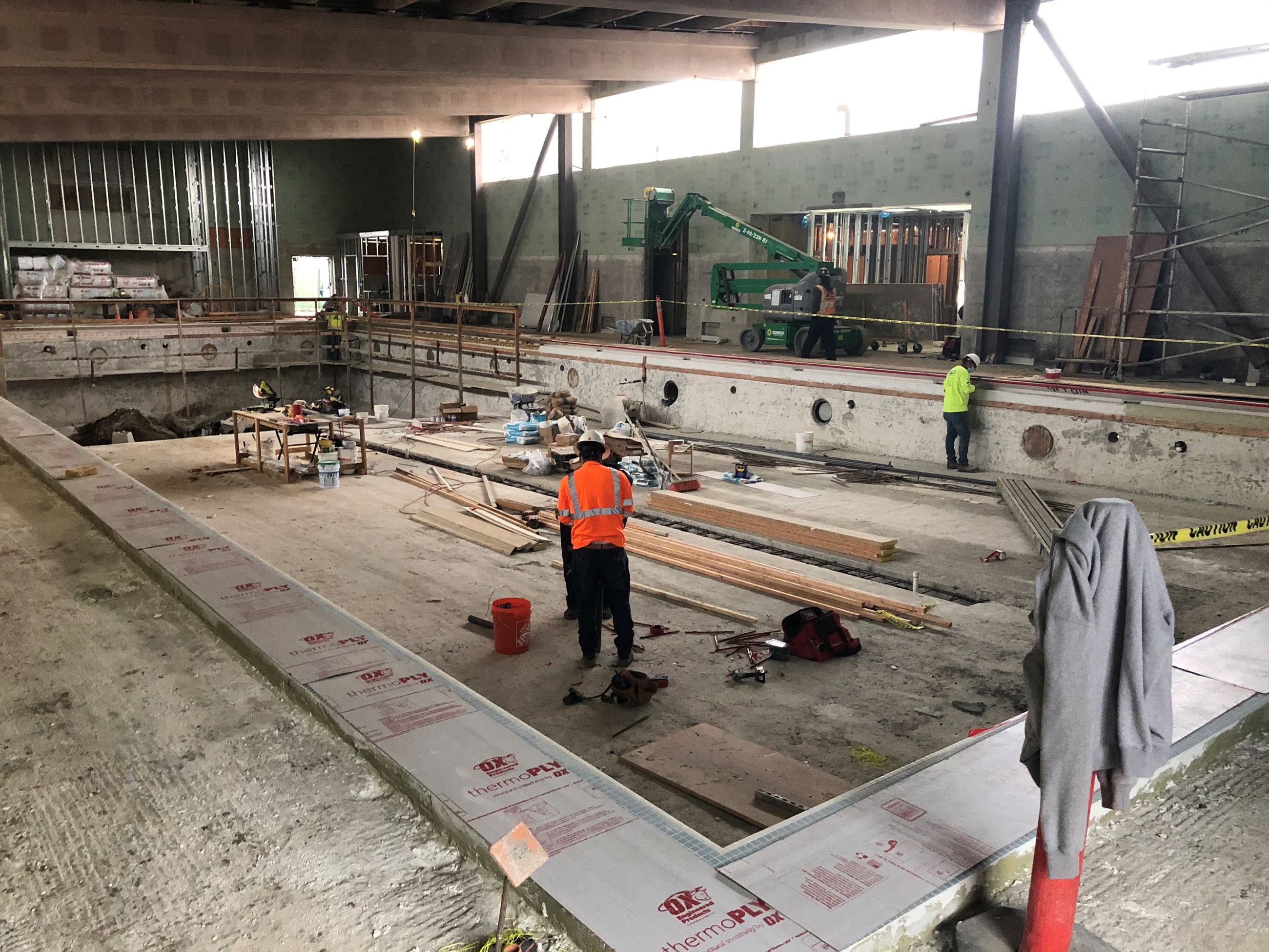 Construction crew working on the interior of the pool.