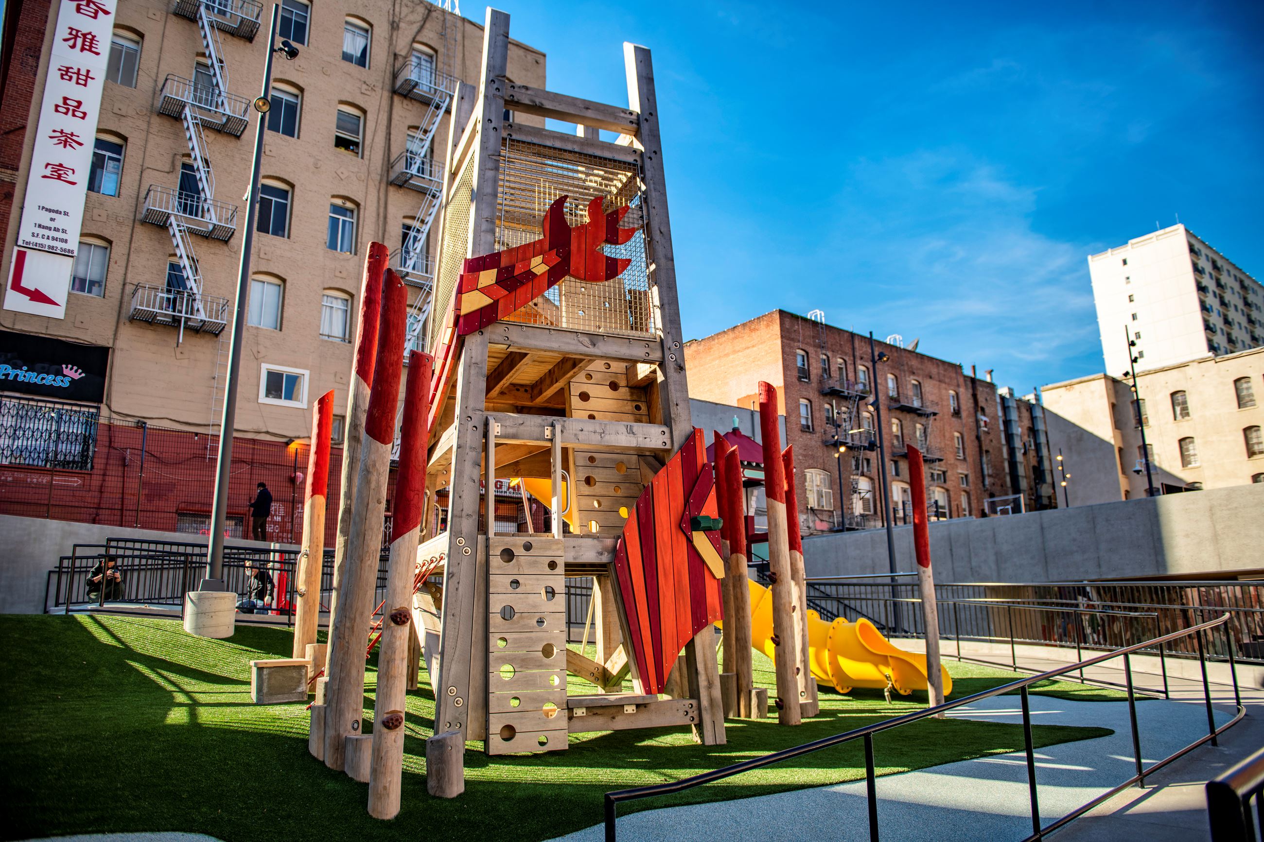 Orange and yellow dragon play structure with climbing elements and slide