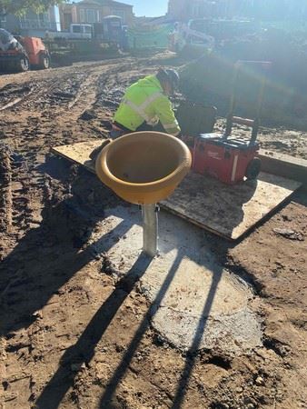 Construction worker wearing yellow safety jacket and hard hat next to red tool box and play