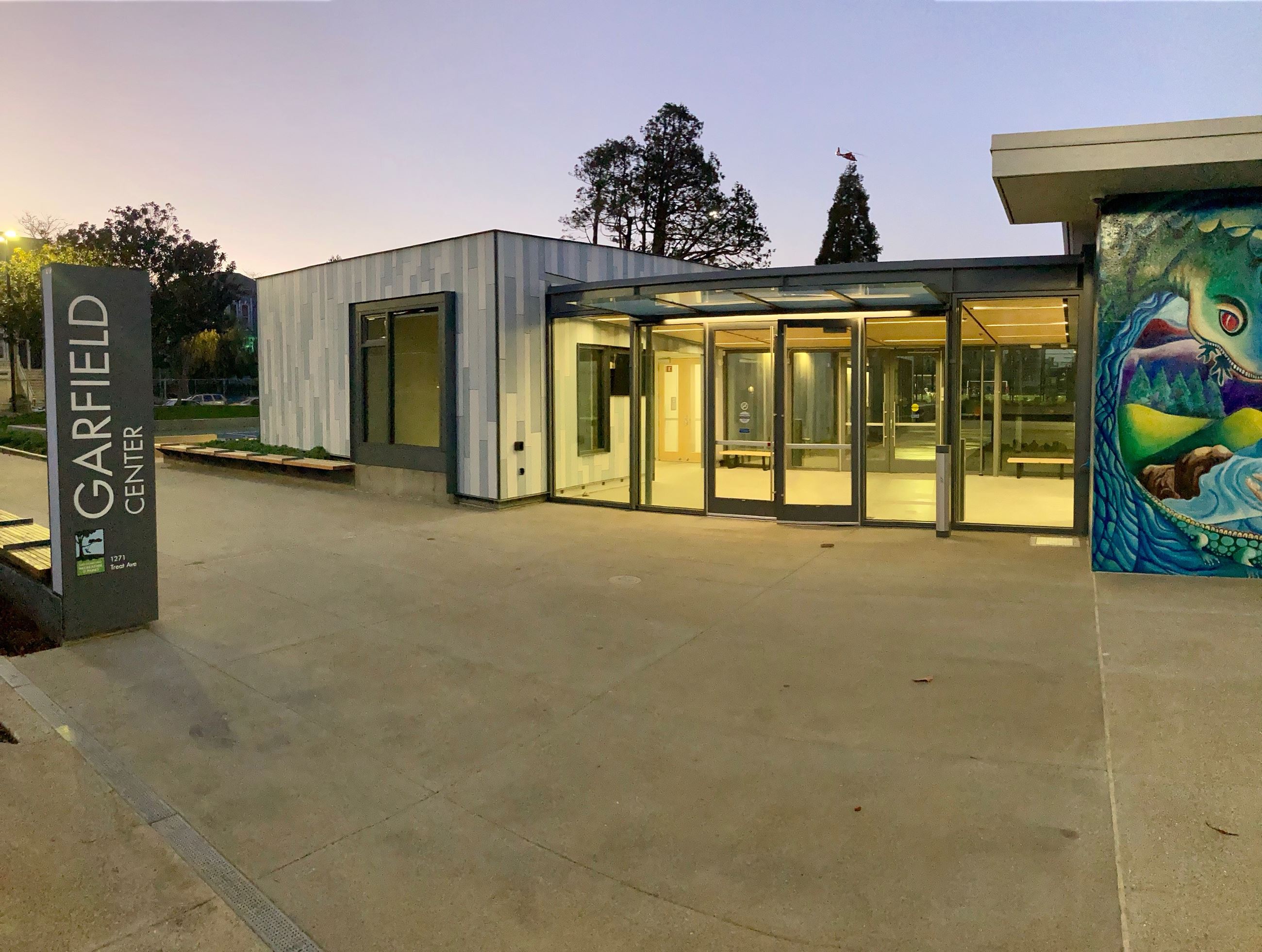 Garfield Center sign outside of the pool and clubhouse building covered in mixed grey tiles.
