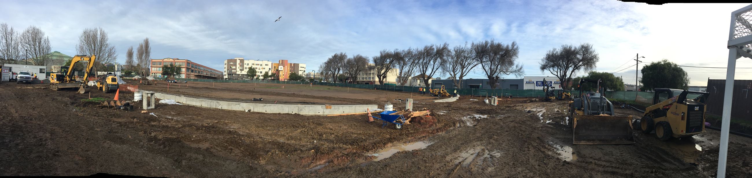 View from homerun fence concrete curb showing construction equipment leveling the dirt field