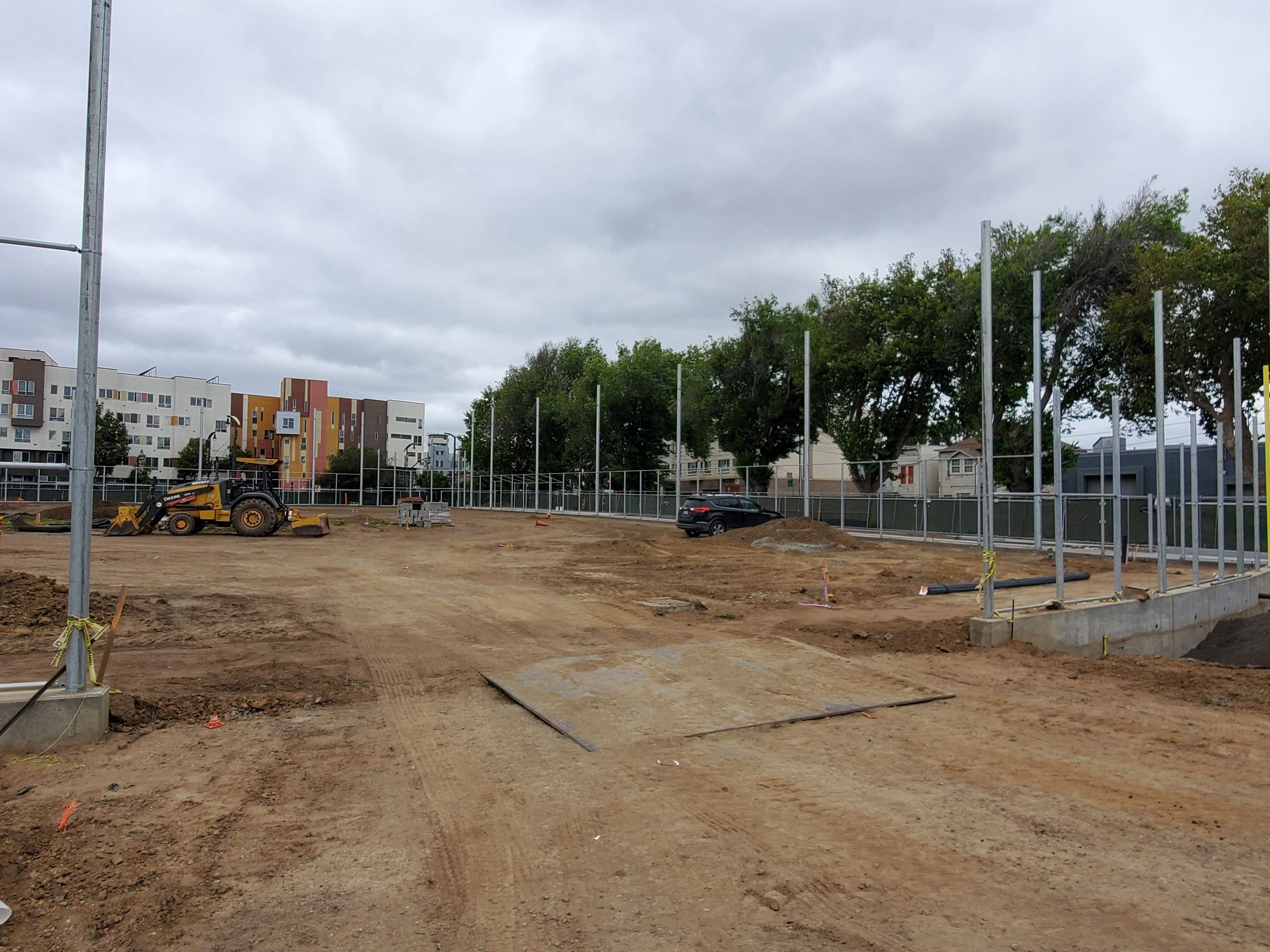Heavy equipment, exposed soil, skeleton of the future ballfield fence.