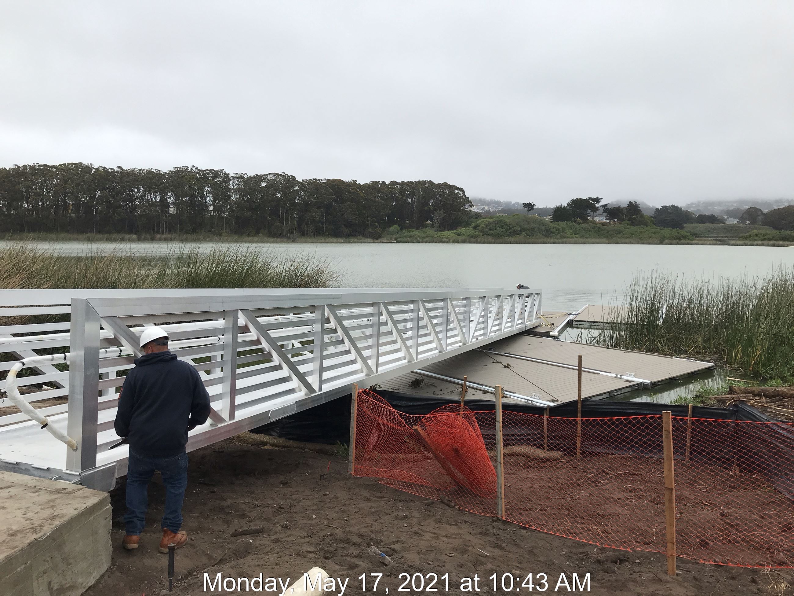 View from side of metal gangway with construction worker.