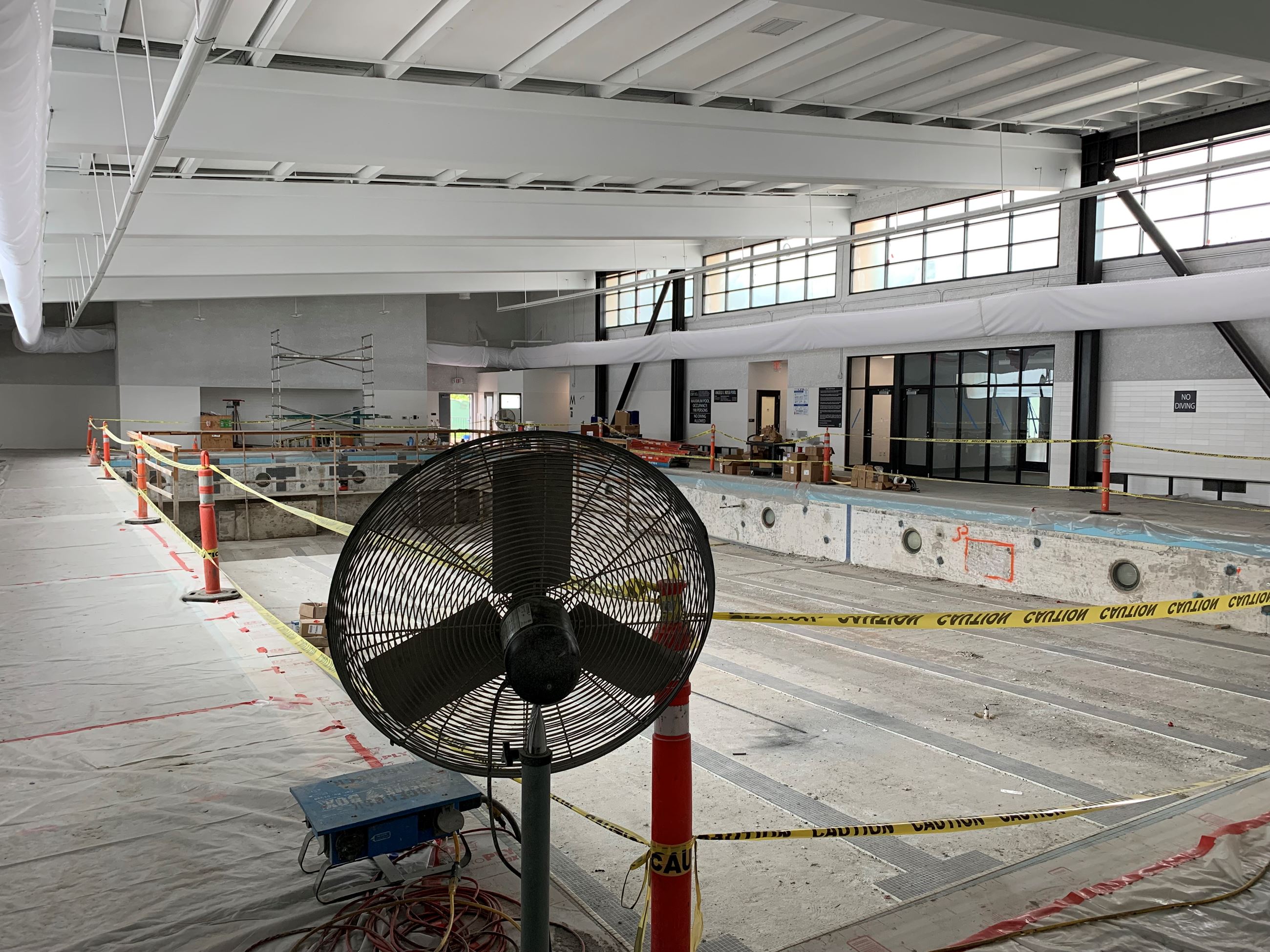 White interior walls with black trimmed windows and doors with empty pool.