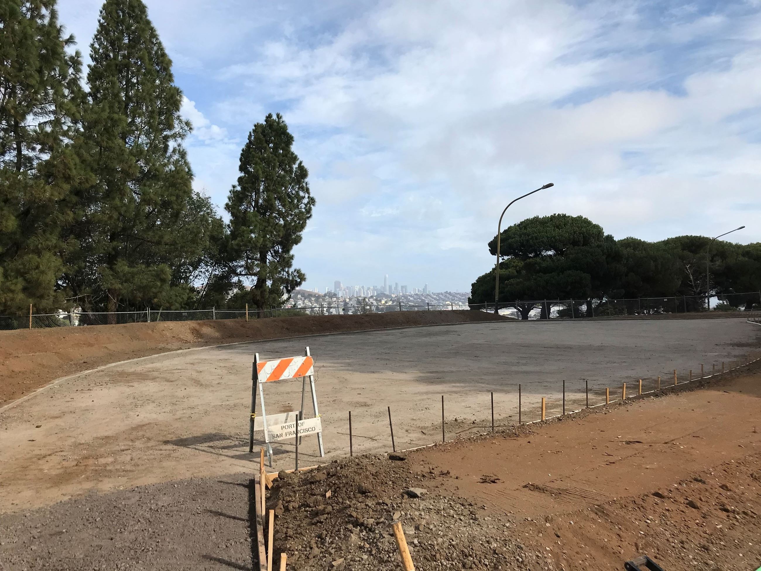 Graded area with crushed gravel base and forms surrounded by earthen mounds