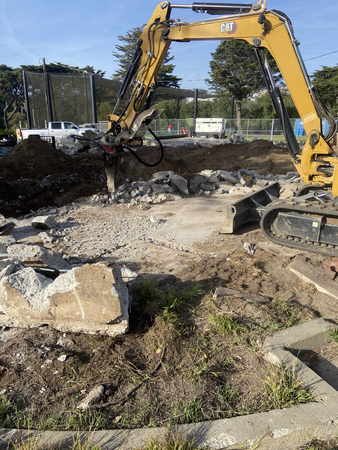 Heavy equipment on the right with debris from demolition.