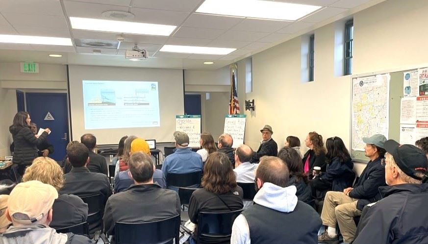 People seated and listening to the Kezar Pavilion presentation