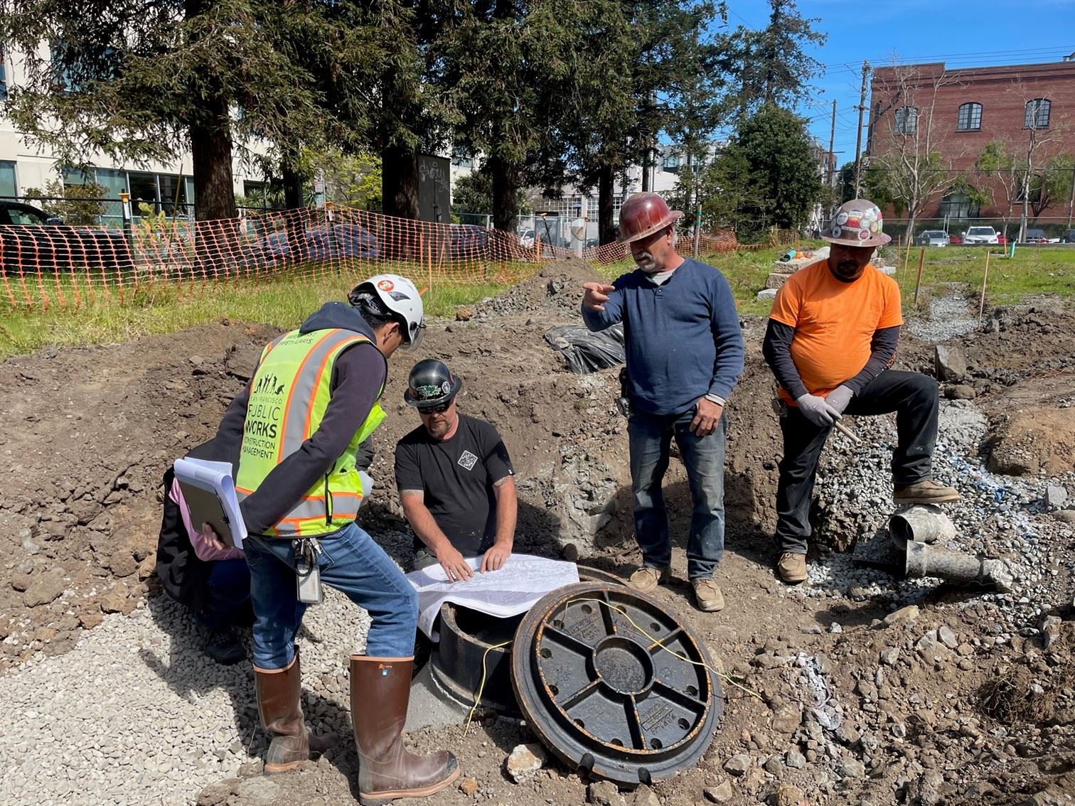 Workers stand over pipes for Site Coordination Related to Subdrainage System