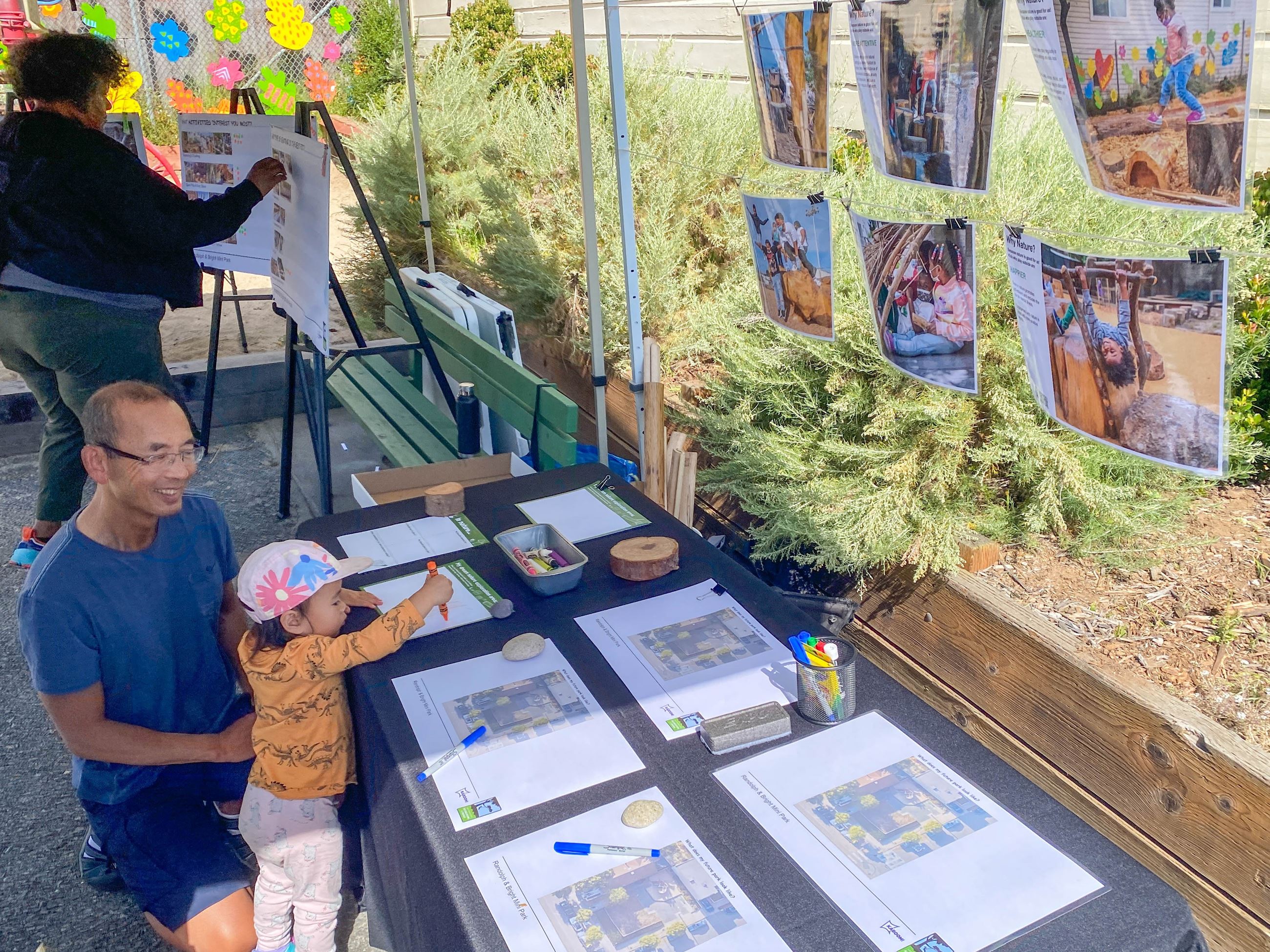 Father and child draw on community feedback boards
