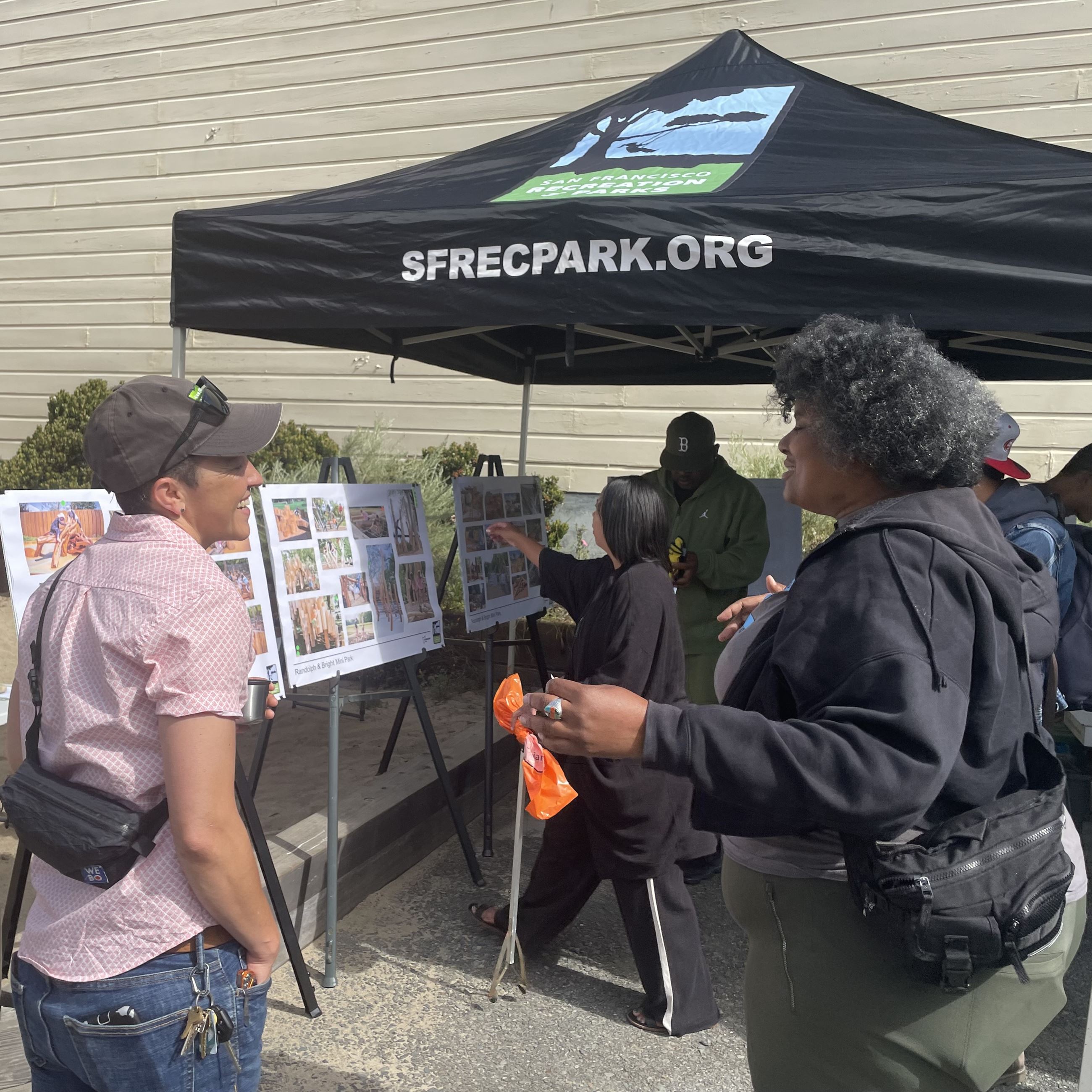 Two people talk outside of the event tent