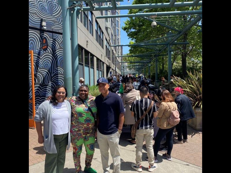 Three people posing for photo in front of job fair