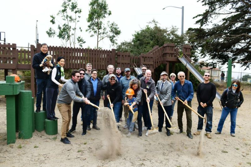 People shoveling sand at playground