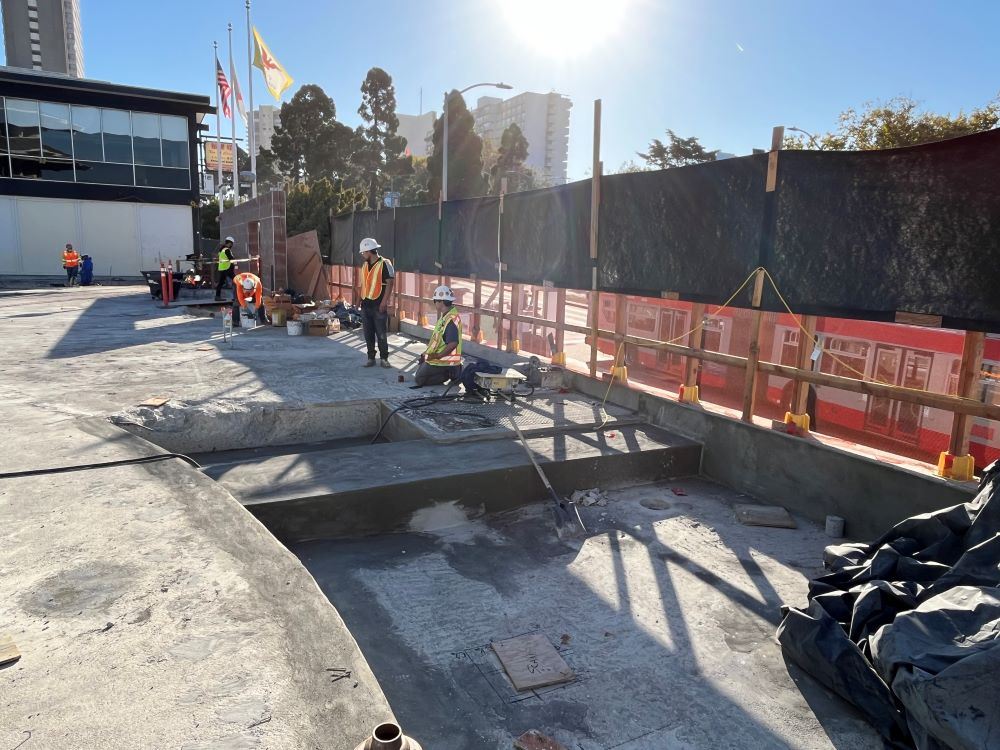 construction workers on bare concrete platform near Geary Boulevard entrance