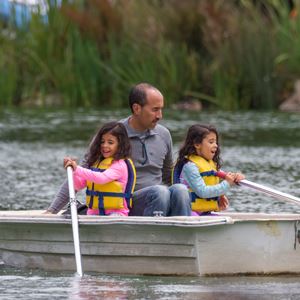 Family rowing a boat on Stow Lake